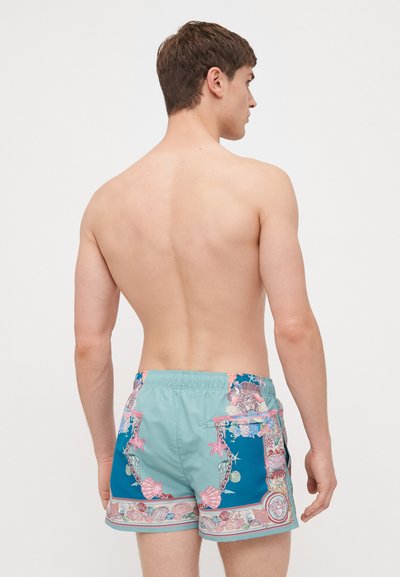 Ανδρικά μαγιό κολύμβησης σε ανοιχτό μπλε χρώμα με περίπλοκα σχέδια κοχυλιού, αντίθετες τουρκουάζ πάνελ, ελαστική μέση και πλαϊνές τσέπες.