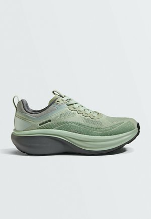 Light green athletic shoe with thick cushioned sole and mesh upper, shown from the side on a plain light background.