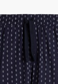 Granatowe bawełniane szorty z elastycznym paskiem w talii, z małymi białymi wzorami zegarków i sznurkiem do regulacji.