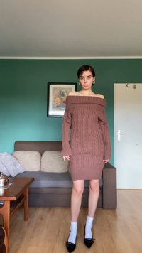 Vestido de malha castanho com decote assimétrico e textura canelada. Manga longa com punhos flare, silhueta ajustada e padrão de trancinha subtil.