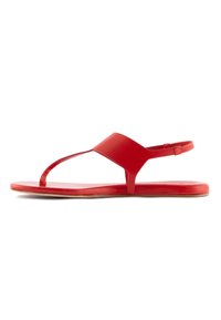 Sandali in gomma rossa dal design minimalista, con una fascia a forma di Y e una cinghia alla caviglia posteriore per una vestibilità sicura. Suola piatta con una leggera texture.