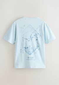 Hellblaues Kurzarmhemd mit einer zarten blauen Illustration eines Sperlings und Blumen in Fächerform, begleitet von japanischem Text.