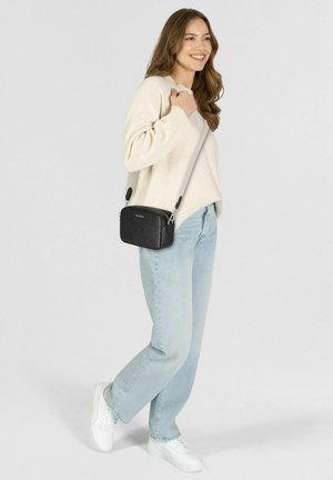 Schwarze Umhängetasche mit geprägt Muster, glattem Leder, verstellbarem hellgrauem Riemen, rechteckiger Form und silbernen Metallakzenten.