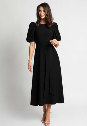 Czarna midi sukienka z bufkami, dopasowanym górą i wiązanym paskiem w talii. Gładki materiał, długość do kostek z rozszerzonym dołem.