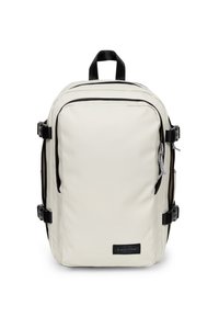 Kremowy prostokątny plecak z czarnymi zamkami, bocznymi klamrami, górną rączką i przednią naszywką z logo Eastpak.