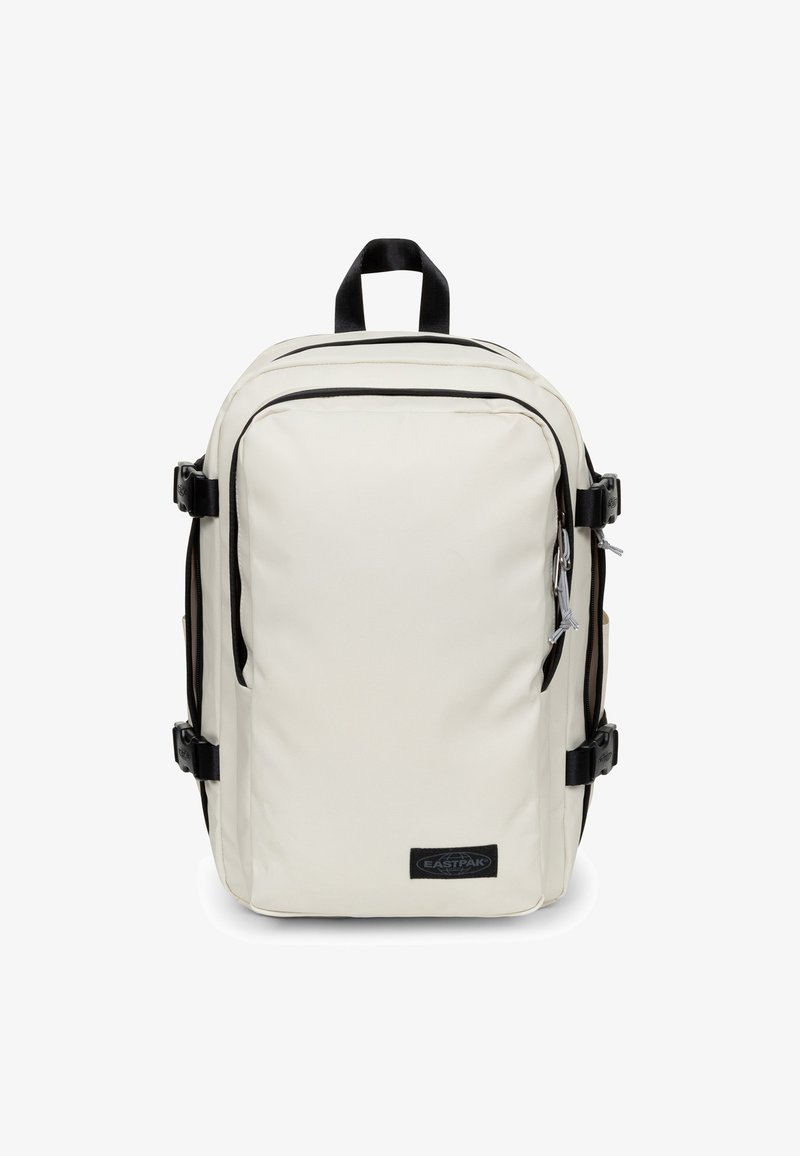 Kremowy prostokątny plecak z czarnymi zamkami, bocznymi klamrami, górną rączką i przednią naszywką z logo Eastpak.