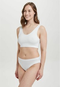 Hvid bomuldsbralette med brede stropper og scoop-udskæring, parret med matchende lavtaljede trusser, der har en glat tekstur og et minimalistisk design.