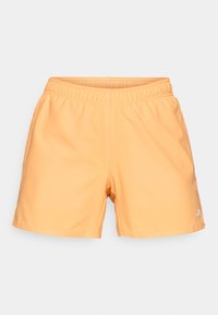 Peach-colored athletic shorts with an elastic waistband, smooth texture, and a small white logo on the lower right side.