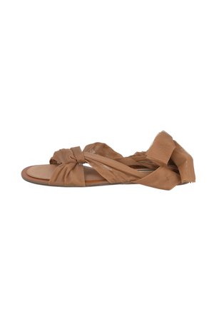 Sandalias planas marrones con tiras de tela transparente anudadas. Diseño de punta abierta con una plantilla suave y una suela flexible.