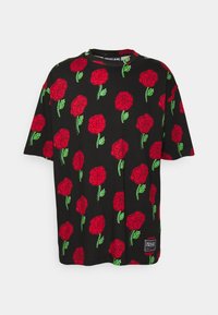 Svart bomullströja med ett mönster av röda rosor och gröna löv över hela. Kort ärm och rund hals. Etikett vid fållen.