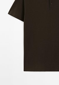 Mörkbrun polo-shirt med en texturerad tyg, korta ärmar och en krage med två knappar. Ren, enkel design, utan mönster eller accenter.