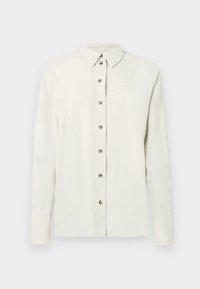 Camisa de manga comprida, bege claro, feita de tecido texturizado, com fecho frontal de botões metálicos e gola clássica.