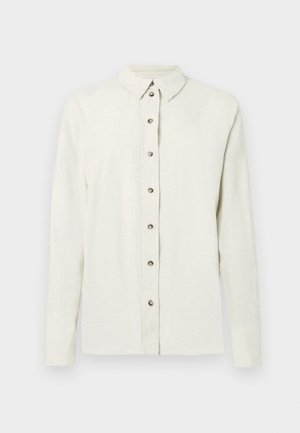 Tričko s dlhým rukávom, svetlo béžovej farby vyrobené z textúrované látky, so zapínaním na gombíky z kovu a klasickým golierom.