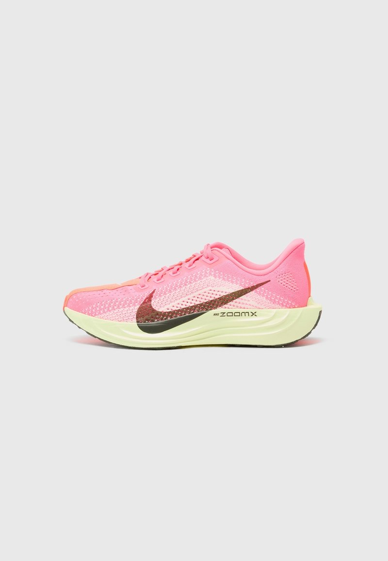 Chaussure de course Nike rose vif avec un grand swoosh noir, semelle vert clair marquée "ZoomX" et empeigne en mesh pour la ventilation.
