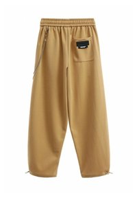 Pantalones jogger color beige hechos de un tejido suave, con una cintura elástica, puños ajustables, un bolsillo lateral y un detalle de cadena decorativa.