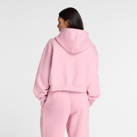 Lichtroze cropped hoodie met een grote capuchon, zachte textuur en geribde zoom, gecombineerd met bijpassende roze joggers die een ontspannen pasvorm tonen.