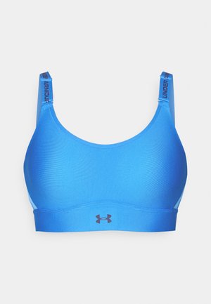 Blå trenings-BH med en glatt tekstur, brede stropper med merkevare og en logo på den fremre elastikken. Sømløst design for komfort.