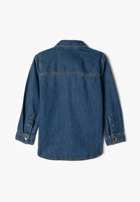 Denimskjorte med en mørkeblå farve, lange ærmer med knapmanchetter og en standard krave. Søm detaljer synlige på ryggen.
