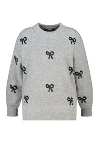 Pull en tricot gris avec des motifs de nœuds noirs, col rond, manches longues et bords ribbés. Texture douce et design décontracté.