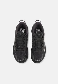 Baskets de sport noires avec une tige en mesh, des accents texturés et des détails réfléchissants. Elles sont dotées de lacets et d'un talon renforcé pour un meilleur soutien.