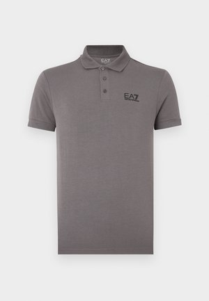 Sivé polo tričko z mäkkej látky, s klasickým golierom, tromi gombíkmi a čiernym logom na ľavej strane hrudníka. Krátke rukávy.