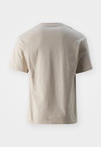 Camiseta corta de manga corta beige claro, hecha de suave algodón. Cuenta con un cuello redondo y un corte recto. Diseño minimalista sin logotipos visibles.