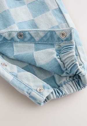 Tessuto in denim azzurro chiaro con motivo a quadri. Presenta bottoni a pressione in metallo ed elastico arricciato ai polsi. Texture morbida.