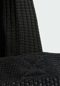 Černá tkaná taška s texturovanou látkou, plochými popruhy a vzorovaným spodkem s diamantovými akcenty. Vhodná pro každodenní nebo neformální použití.