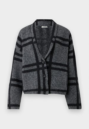 Tumši pelēkā krāsā sasmalcināts kardigāns, kas izgatavots no mīkstas vilnas, ar melnu pārbaudes rakstu, šallē līdzīgu apkakli un divām melnām pogām priekšpusē.