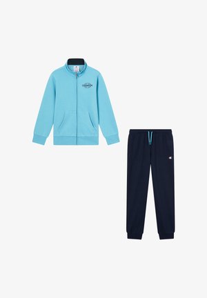 Chaqueta azul claro con cremallera y dos bolsillos frontales, acompañada de pantalones de chándal azul marino con cintura elástica y detalle del logo en la pierna.
