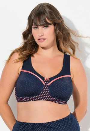 Dunkelblauer BH mit rosa Punkten und Besatz, ausgestattet mit einer zentralen Schleifendetail. Weicher Stoff, glatte Cups und verstellbare, breite Träger.