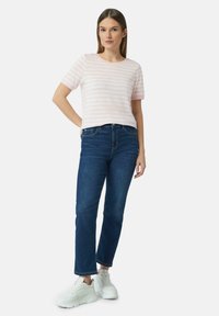 Rood en witte gestreepte t-shirt met korte mouwen in combinatie met donkerblauwe slim-fit jeans en witte sneakers. Eenvoudig ontwerp, lichtgewicht stof.