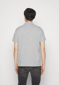 Grå polo T-shirt med klassisk krave og korte ærmer, lavet af blødt stof, har en subtil tekstur og en lige kant.