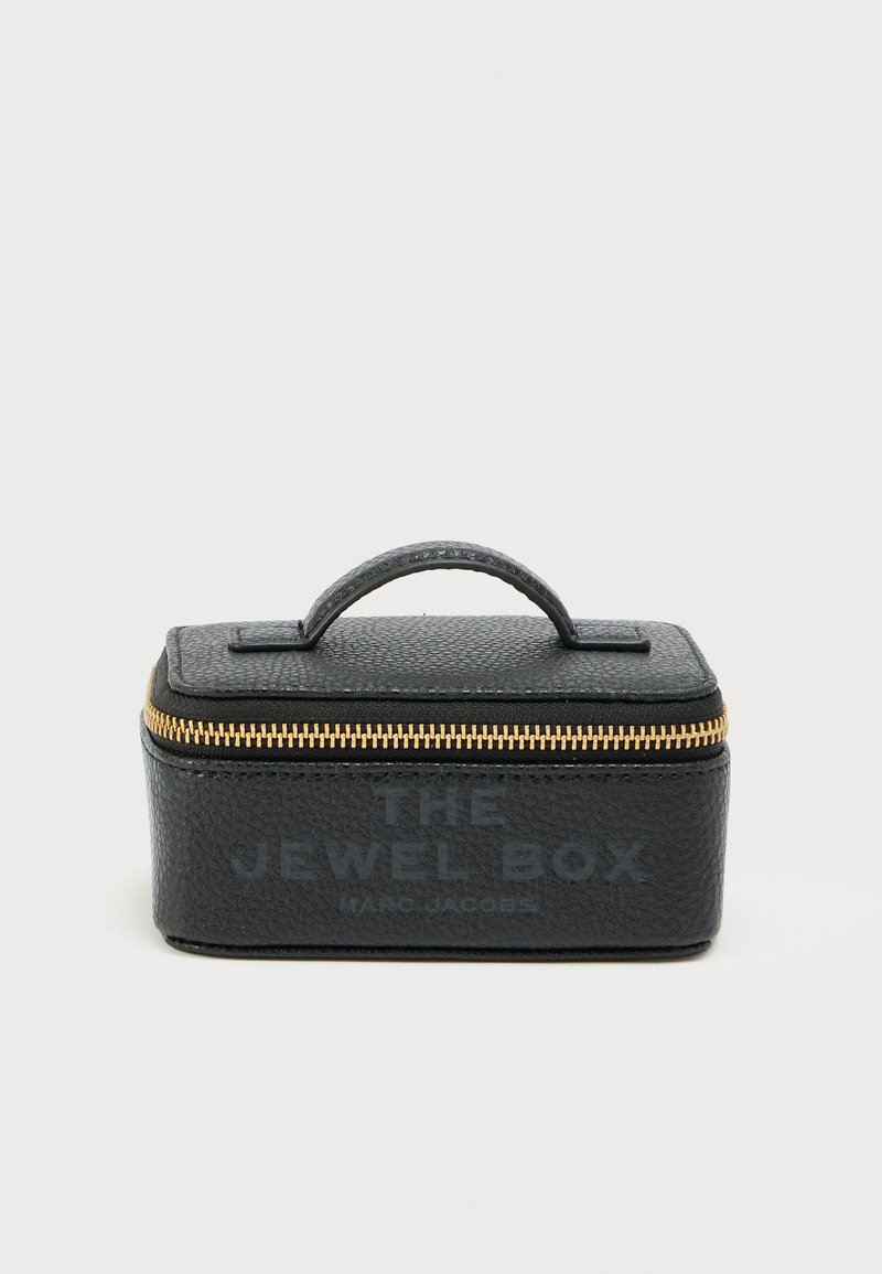 Κουτί κοσμημάτων από μαύρο δερμάτινο υλικό με υφ ή, ορθογώνιο σχήμα, χρυστό φερμουάρ, πάνω λαβή και ανάγλυφο κείμενο στην μπροστινή πλευρά.