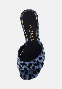 Υφασμάτινο σανδάλι με λουράκι, με μπλε σχέδιο λεοπάρδαλης. Διαθέτει μαύρη εσωτερική σόλα με το λογότυπο «GUESS» σε χρυσό. Μαλακή, πολυτελής υφή.