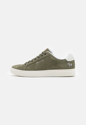 Olijfgroen suède sneaker met witte leren accenten, ronde neus, platte veters en een klein zebra-graphic op de hiel. Witte rubberen zool.