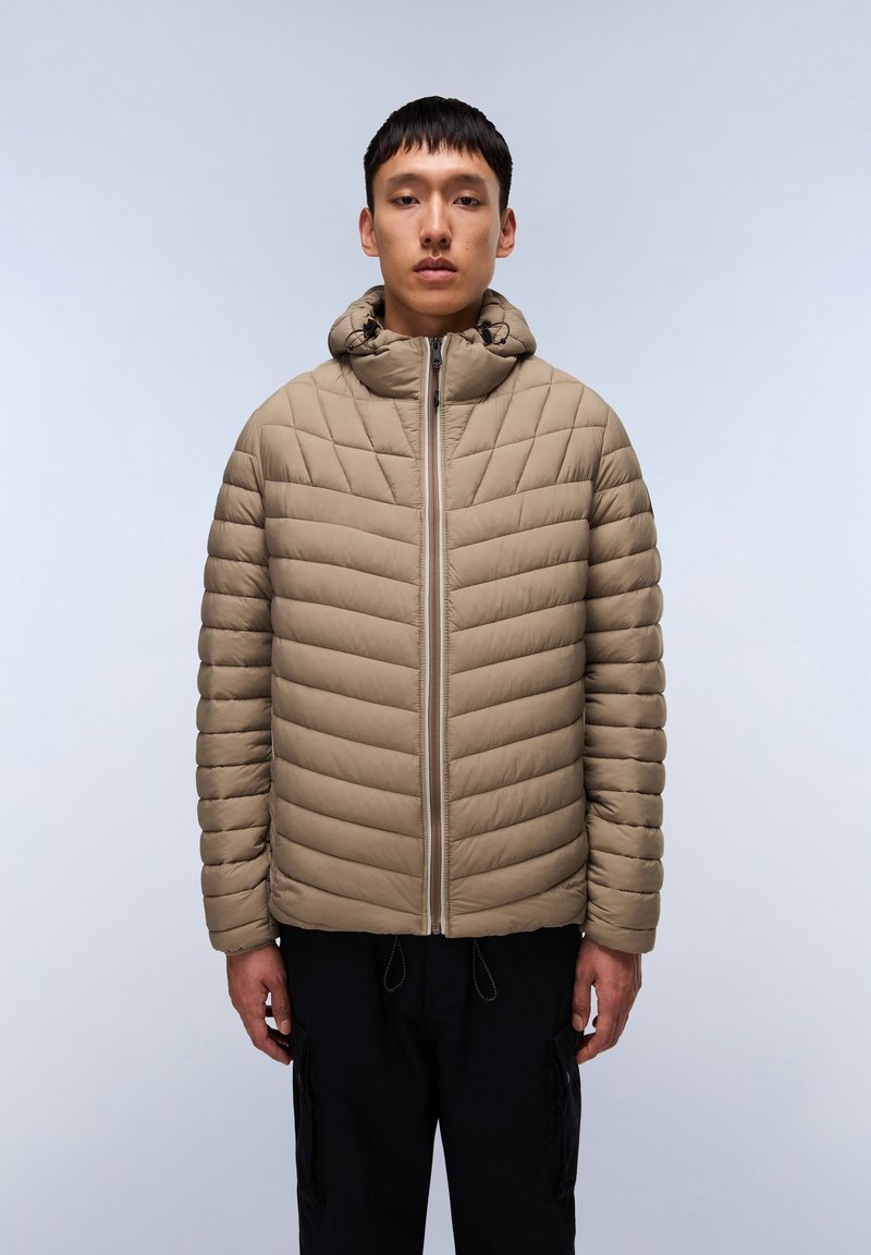 Beige quiltet pufferjakke med hætte, frontlynlås og ribbet tekstur. Har elastiske snore i kanterne og et minimalistisk design.