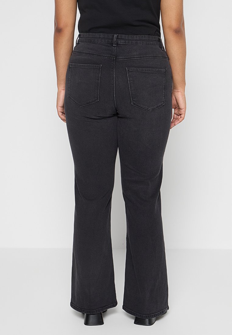 Schwarze weit geschnittene Jeans mit mittelhohem Bund, aufgesetzten Taschen und einer glatten Stoffoberfläche. Das Design weist eine klassische Denim-Silhouette auf.