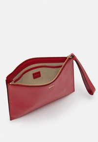 Red leather wristlet pouch with gold zipper, beige interior lining, card slots, and Furla logo on front and inside pocket.