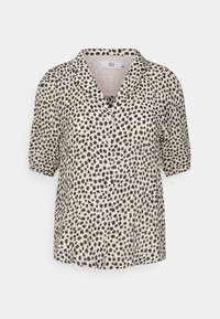 Blusa a maniche corte di un beige chiaro con un motivo floreale nero. Presenta un colletto e una chiusura a bottoni, realizzata in un tessuto leggero.