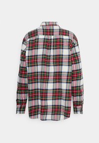 Camicia a maniche lunghe a quadri con una base bianca caratterizzata da linee incrociate rosse, verdi, blu e rosa, e un dettaglio della cucitura del giromanica sul retro.