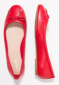 Ballerines en cuir rouge à bout arrondi, avec un accent en nœud et des détails en or. Intérieur doux et semelles plates.