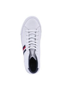 Zapatilla de cuero blanca con punta redonda, cordones planos blancos y un acento a rayas en azul y rojo. Textura suave con un logo en relieve en el interior.