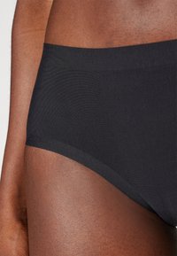 Black cotton brief with a smooth texture and elastic waistband, featuring a simple design and seamless edges for comfort.