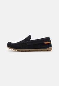 Slip-On-Schuhe aus dunkelblauem Wildleder mit einer sandfarbenen Gummisohle. Sie haben einen leicht erhöhten Absatz und dekorative Nähte entlang der oberen Kante.