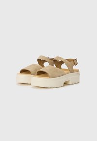 Beige velúr platform szandálok keresztpántos kialakítással, nyitott orral és állítható csatos részlettel. Vastag gumitalp a tapadásért.