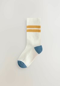 Weiße gerippte Socke mit einer blauen Zehe und Ferse, die oben mit zwei gelben Streifen verziert ist. Aus weichem, flexiblem Material gefertigt.