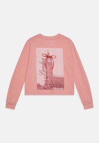 Camiseta de manga larga rosa con un gráfico frontal de Big Ben, una escena de Londres y un acento de lazo rojo. Material de algodón suave y ligero.