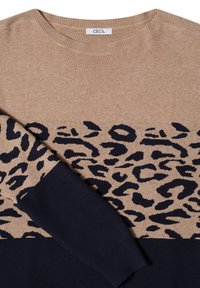 Pull beige et noir avec motif léopard sur la poitrine et les manches, avec un col rond et une étiquette "CECIL" à l'intérieur du col.