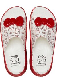 Hello Kitty-Themen-Sandalen aus weißem und rotem Kunststoff. Sie verfügen über eine glänzende rote Schleife oben, mit aufgedruckten Hello Kitty-Gesichtern und einem strukturierten Fußbett.